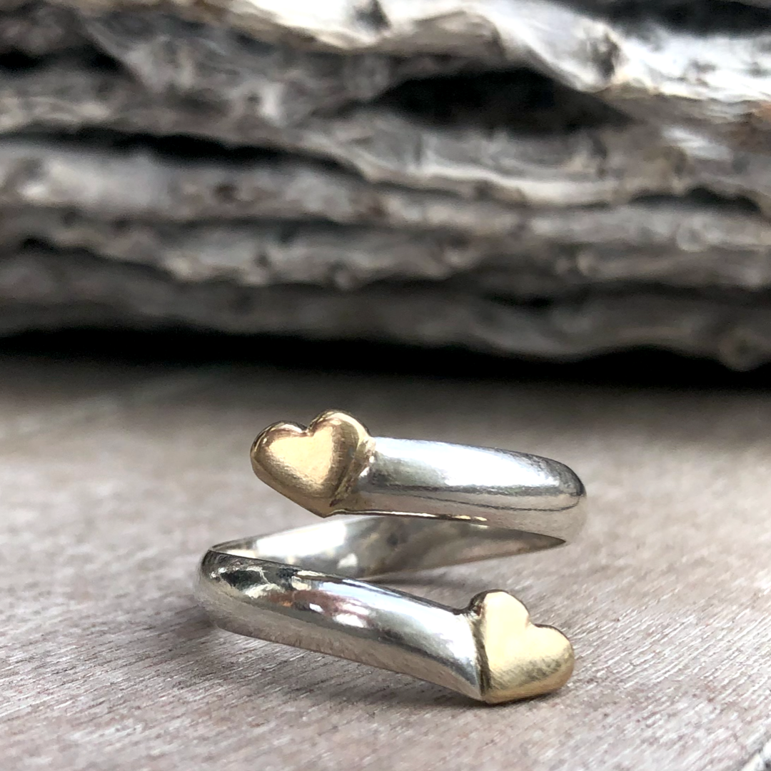 Solid silver twist ring with two gold hearts