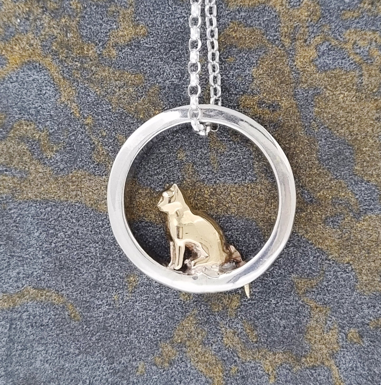 Teeny tiny gold cat peeping out of silver halo