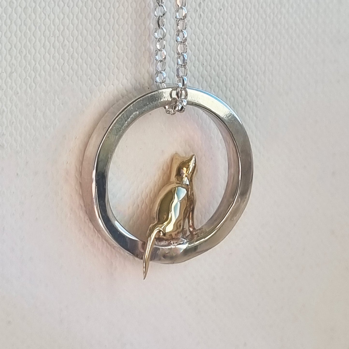 Teeny tiny gold cat peeping out of silver halo