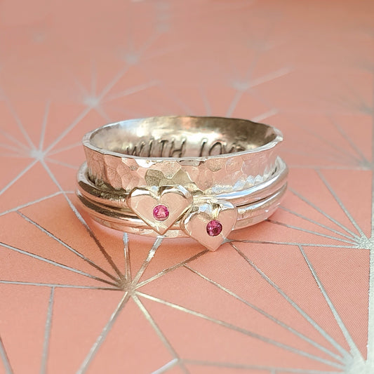 Pink to make the boys wink. Silver spinning ring with silver hearts and sparkling pink sapphires