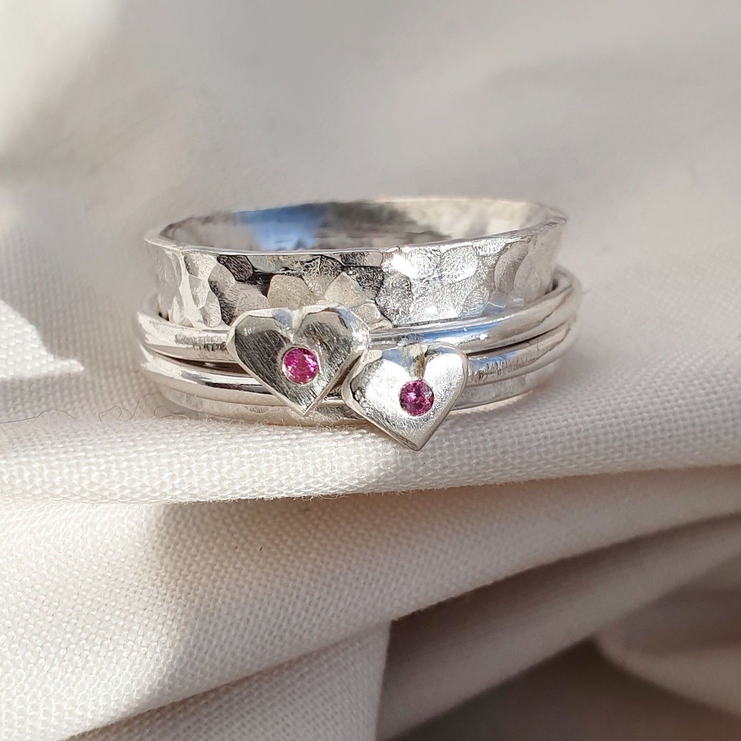 Pink to make the boys wink. Silver spinning ring with silver hearts and sparkling pink sapphires