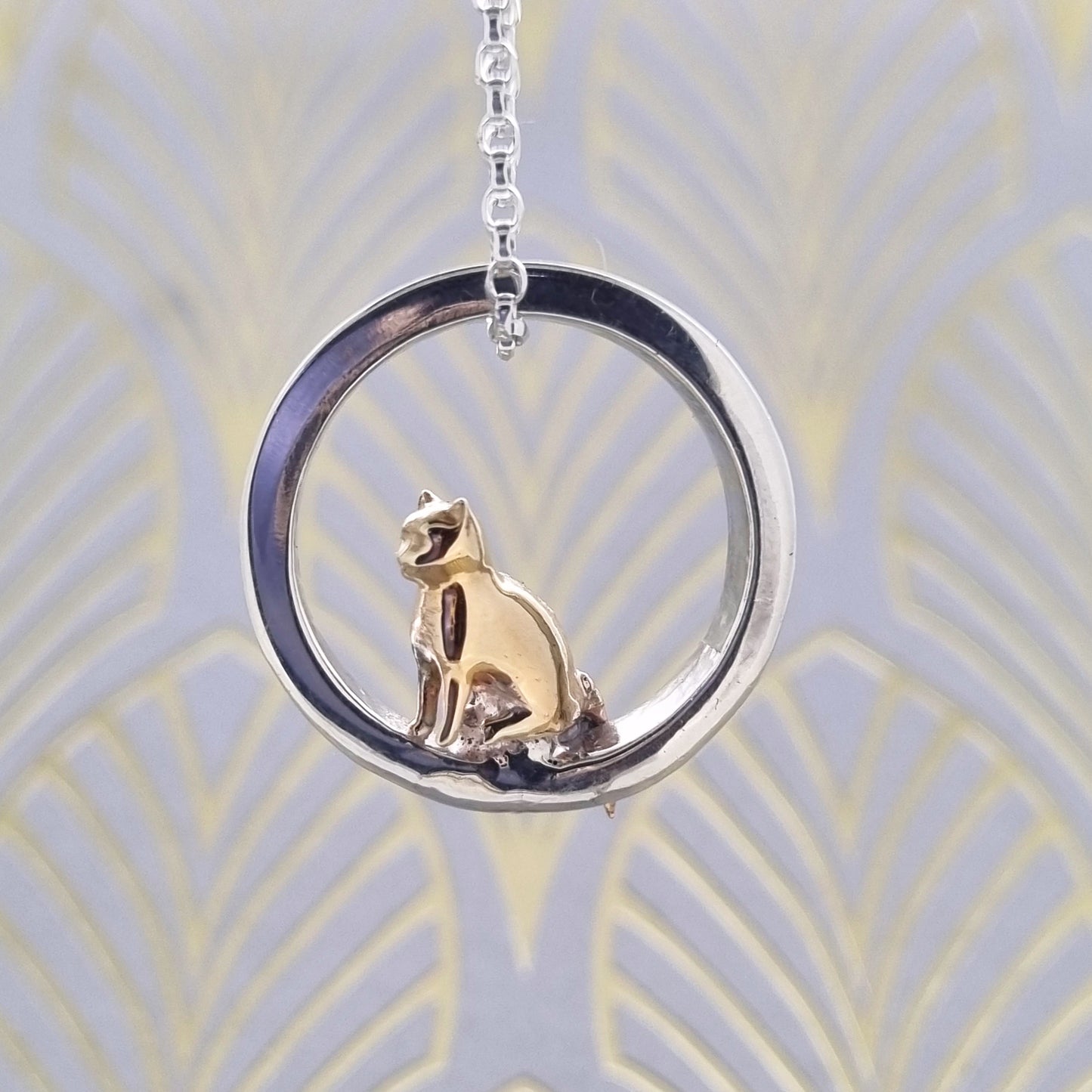 Teeny tiny gold cat peeping out of silver halo