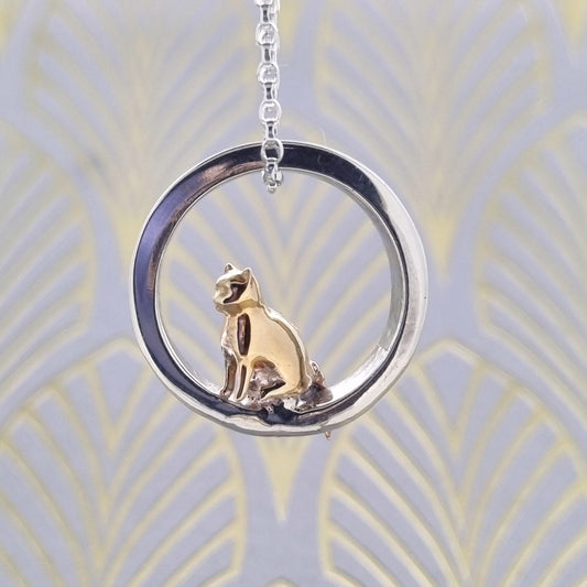 Teeny tiny gold cat peeping out of silver halo