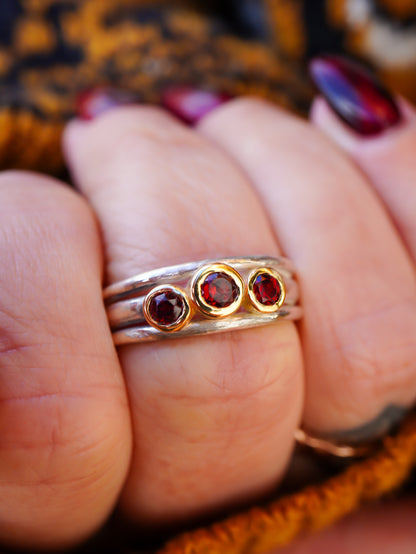 'Cariad lite' with garnets -  Crimson gemstones in gold settings on a sleek silver ring