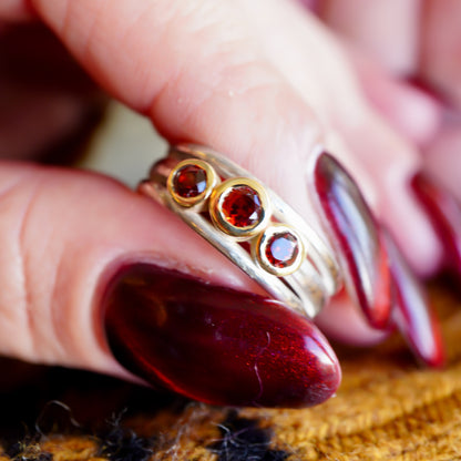 'Cariad lite' with garnets -  Crimson gemstones in gold settings on a sleek silver ring