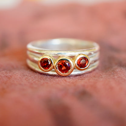 'Cariad lite' with garnets -  Crimson gemstones in gold settings on a sleek silver ring