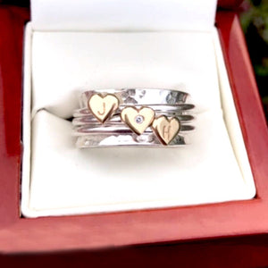Spinning ring with diamonds set in three gold hearts