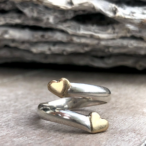 Solid silver twist ring with two gold hearts
