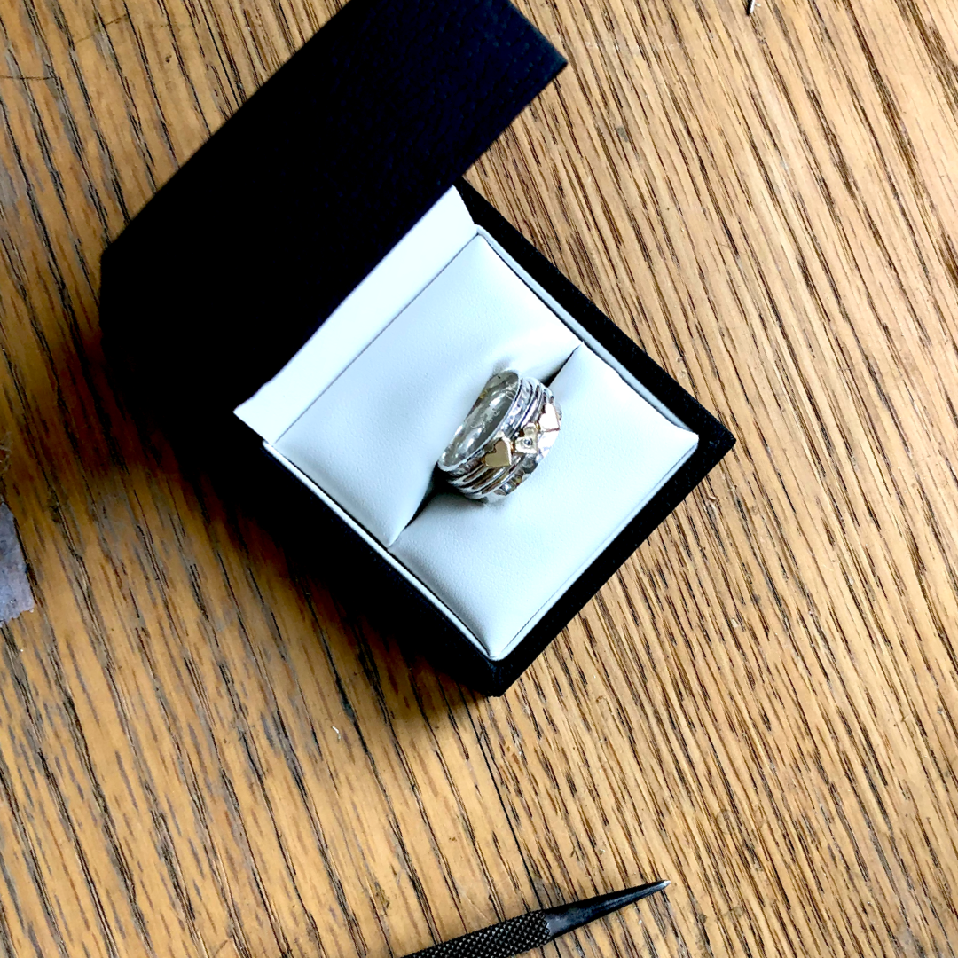 Spinning ring with diamonds set in three gold hearts