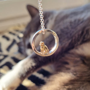 Teeny tiny gold cat peeping out of silver halo