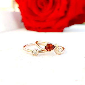 Gold stacking ring set with garnet and diamonds.