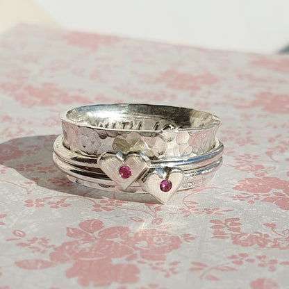 Pink to make the boys wink. Silver spinning ring with silver hearts and sparkling pink sapphires